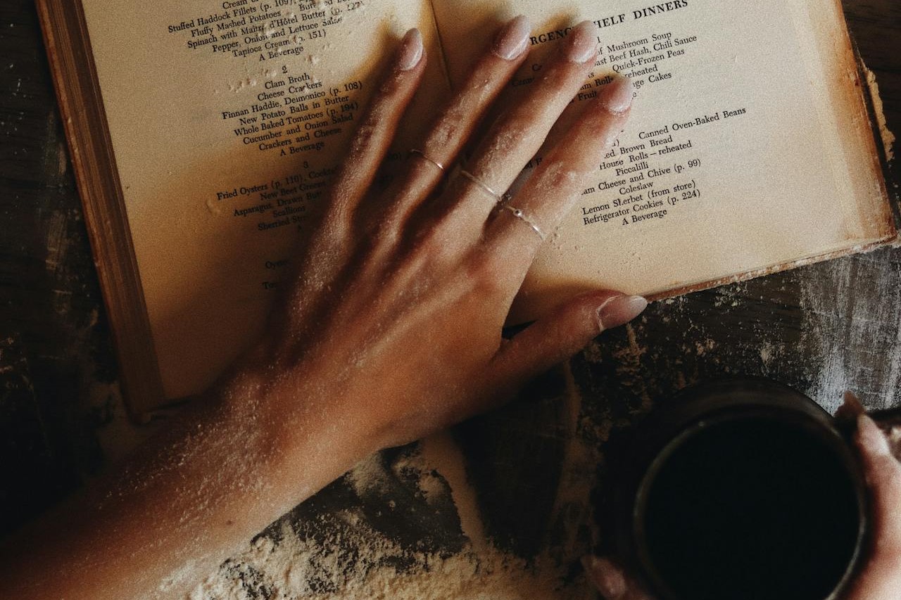Photo by Daniel & Hannah Snipes: https://www.pexels.com/photo/hands-preparing-bread-with-coffee-and-cookbook-29666877/